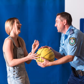 Man passing a basketball to a girl
