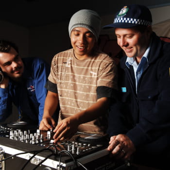 DJ showing the digital turntable to 2 men