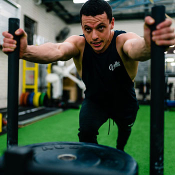 man pushing a crossfit sled