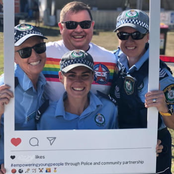 police officers posts behind a cardboard cutout